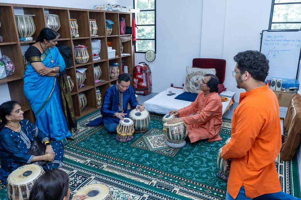 Senior Parliamentary Secretary Eric Chua playing the tabla during a tour of the SIFAS Middle Road campus.