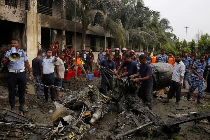 Firefighters working to remove the wreckage from a building on July 21, after an air force training aircraft crashed into Milestone College campus, in Dhaka, Bangladesh.