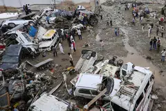 Residents look at damaged vehicles after flash flood and landslide triggered by heavy rains wreaked havoc at Rajouri district in India's Jammu region