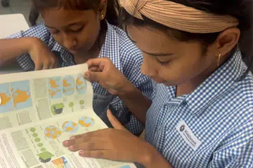 A couple of Middleton International School students reading a book.