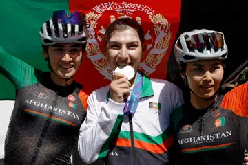 Silver medallist Afghanistan's Fariba Hashimi (centre) celebrates with teammates Yuldoz Hashimi and Zahra Rezayee during the victory ceremony