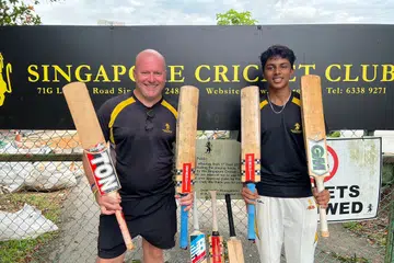 Singapore Cricket Club (SCC) Cricket Academy CEO David Bennett (left) and Advait Swaminathan with some of the bats they collected from SCC members.