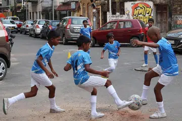 Children play football on a street in Kolkata.