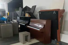 The rubbish collection point in a condo resembles a graveyard for pianos.