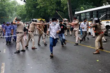 Policemen wielding batons against demonstrators near Jantar Mantar, New Delhi, on July 20.