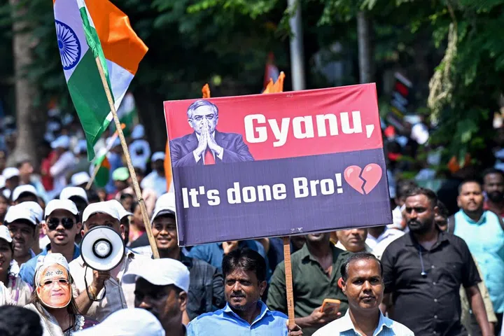 A protester carries a placard next to India's national flag during a demonstration calling for the resignation the country's Chief Election Commissioner Gyanesh Kumar over alleged irregularities in the Special Intensive Revision (SIR) of electoral rolls, in Mumbai on October 4, 2026.