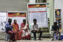 Relatives of the Indian woman who fell into an 8m-deep sinkhole waiting for news about her near the accident site in Kuala Lumpur.