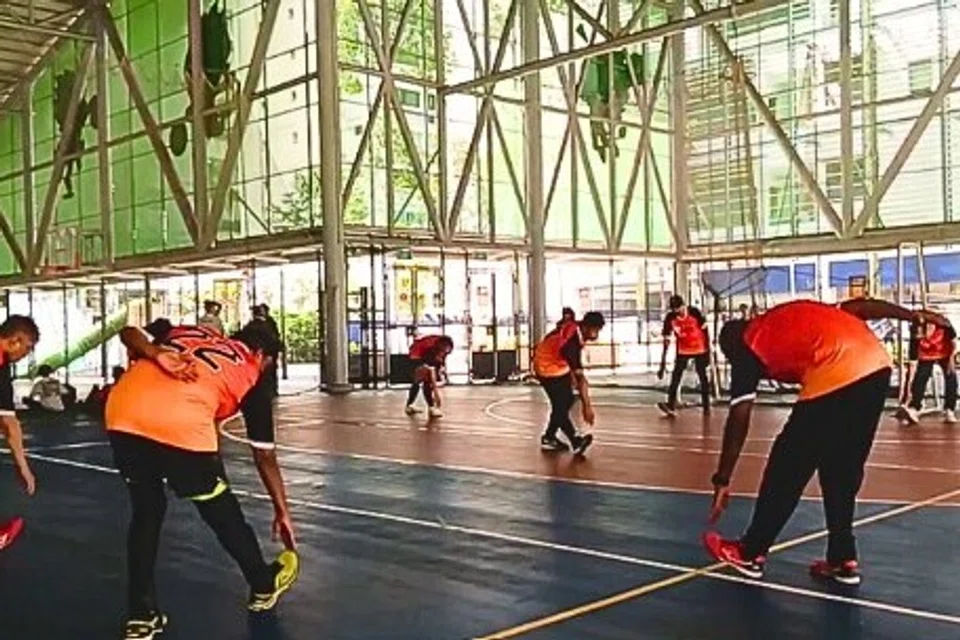 The team doing stretching exercises before playing football.