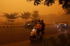 Motorists commute in the morning in Palangkaraya, Central Kalimantan, on October 14, amid thick haze from forest and land fires in the region. Toxic haze has shrouded parts of Indonesia, Malaysia and Singapore for weeks as Jakarta struggles to contain fires that have scorched large tracts of Borneo and Sumatra, with the smoke drifting across the region.