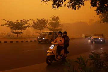 Motorists commute in the morning in Palangkaraya, Central Kalimantan, on October 14, amid thick haze from forest and land fires in the region. Toxic haze has shrouded parts of Indonesia, Malaysia and Singapore for weeks as Jakarta struggles to contain fires that have scorched large tracts of Borneo and Sumatra, with the smoke drifting across the region.
