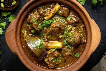 Slow-cooked chunks of goat meat in an earthen pot.
