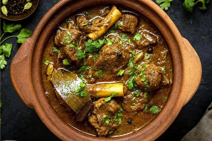 Slow-cooked chunks of goat meat in an earthen pot.