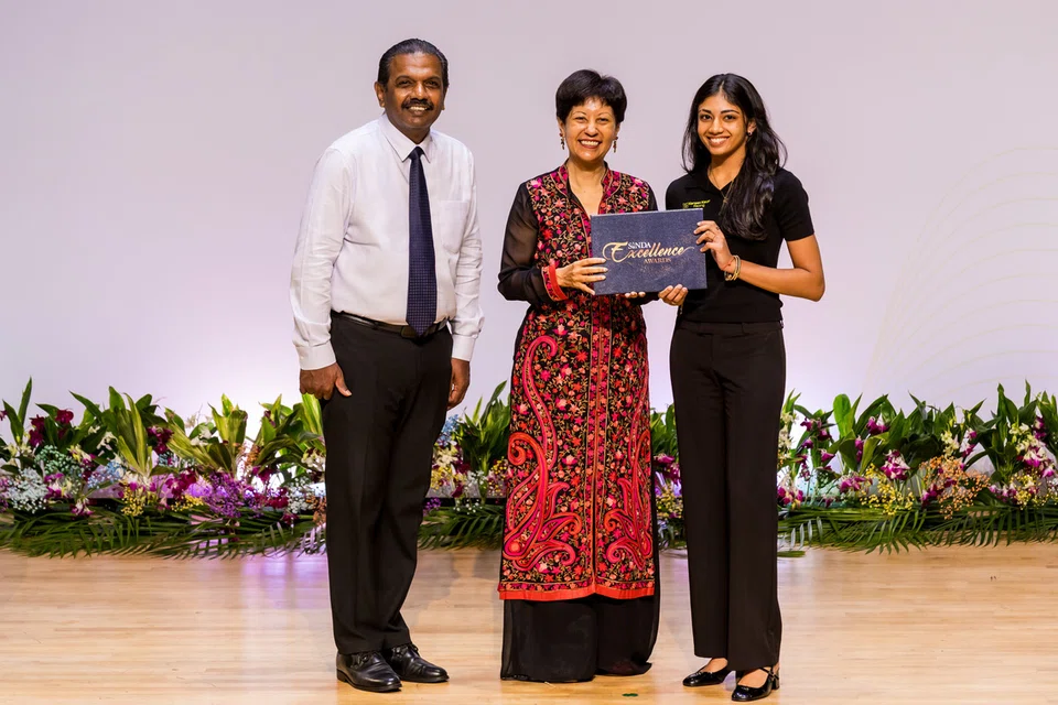 Singapore’s first female Formula 4 race driver, Kareen Kaur (right), receiving an award from Minister in the Prime Minister’s Office Indranee Rajah. SINDA Chief Executive Officer Anbarasu Rajendran was also present.