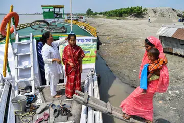 A medic measures the height of a pregnant woman at a mobile boat clinic in Mukalmua village of Assam's Nalbari district.