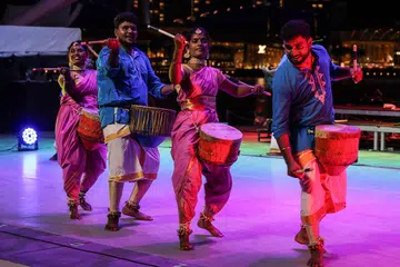 Dancers from India performing the thudumbattan, while playing the uruttu drum.