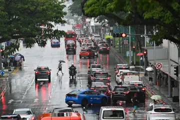 People crossing Geylang Road under the rain as seen from overhead bridge next to Haig Road Market & Food Centre on Sept 27, 2026.  Meanwhile, the temperature fell to a low of 20.7 deg C at Clementi Road.