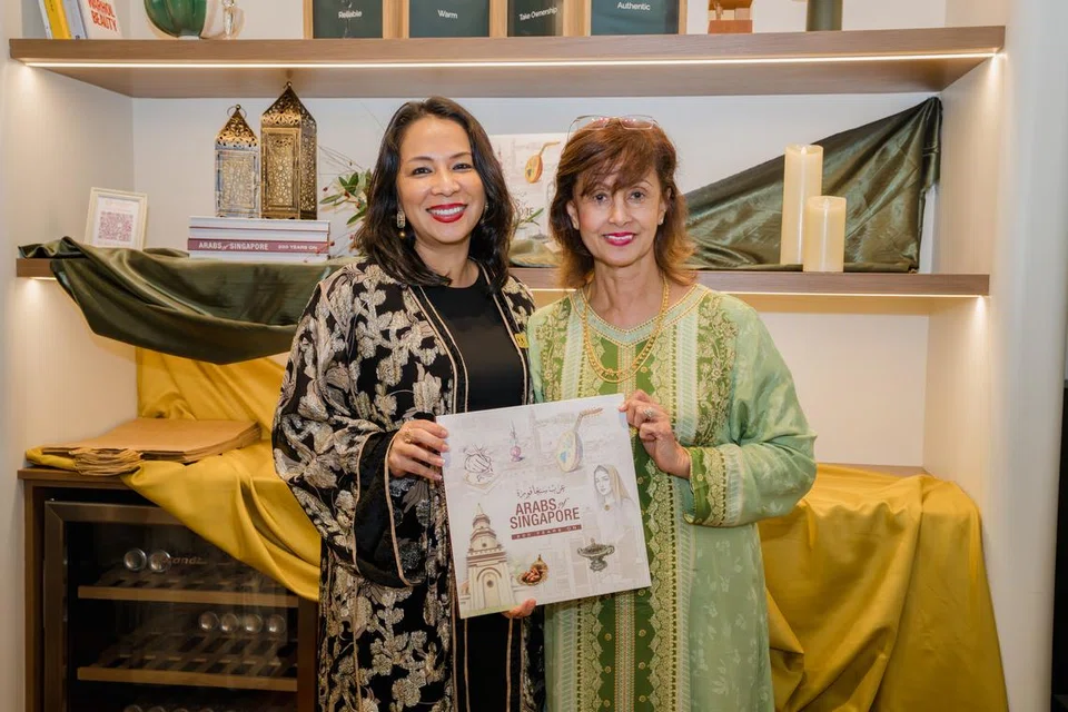 Ms Juliana Mattar (left) and Ms Khadijah Alattas with a copy of the coffee-table book, Arabs of Singapore: 200 Years On.