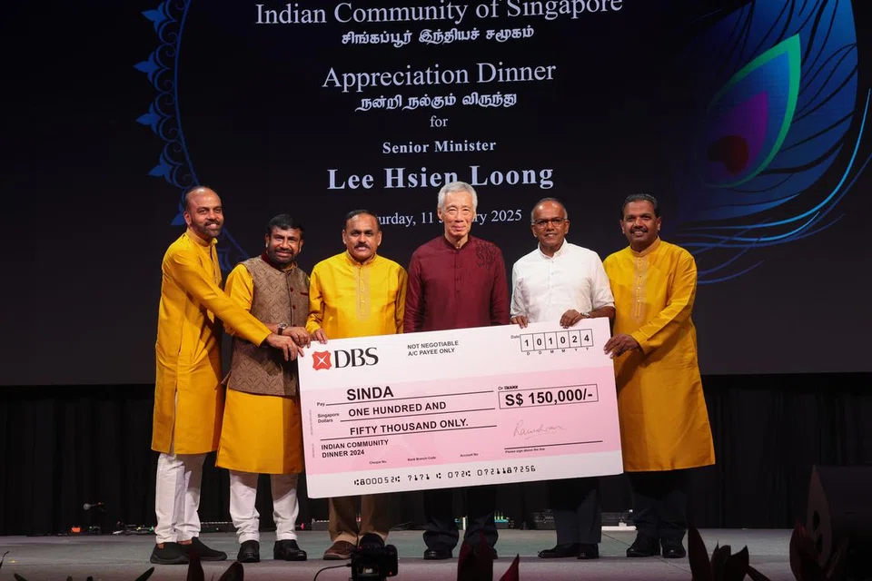 மூத்த அமைச்சர் லீ சியன் லூங்கிற்கு (நடுவில்) நன்றி தெரிவிக்கும் நிகழ்ச்சியின் மூலம் திரட்டப்பட்ட நிதியிலிருந்து $150,000 நன்கொடைக்கான மாதிரிக் காசோலை சிண்டாவுக்கு வழங்கப்பட்டது.