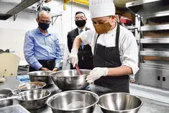 பார்க்ராயல் கலெக்‌ஷன் மரினா பே ஹோட்டலுக்கு நேற்று வருகை புரிந்த சமுதாய, குடும்ப மேம்பாட்டு அமைச்சர் மசகோஸ் ஸுல்கிஃப்லி (இடது) அங்கு கேக், பலகாரங்கள் செய்யும் பிரிவில் பணியாற்றும் கிலாசன் சியோங்கின் (வலது) வேலையைப் பார்வையிடுகிறார். நடுவில் அந்த ஹோட்டலின் பொது மேலாளர் திரு மெல்வின் லிம். படம்: ஸ்ட்ரெய்ட்ஸ் டைம்ஸ் 