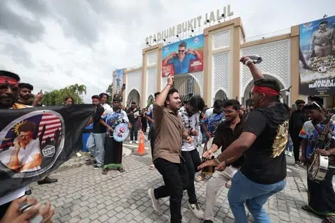 இசை வெளியீட்டு விழாவை முன்னிட்டு புக்கிட் ஜலில் விளையாட்டரங்கிற்கு வெளியே ஆடும் ரசிகர்கள்.