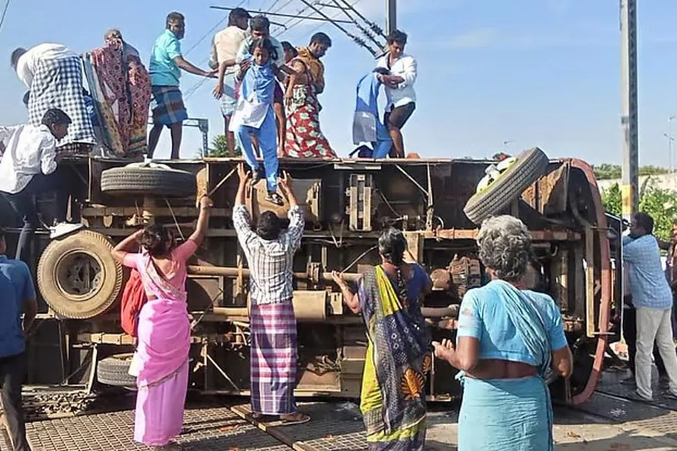 விபத்துக்குள்ளான பள்ளி வாகனத்திலிருந்து மாணவர்களை மீட்கும் அப்பகுதி மக்கள்.