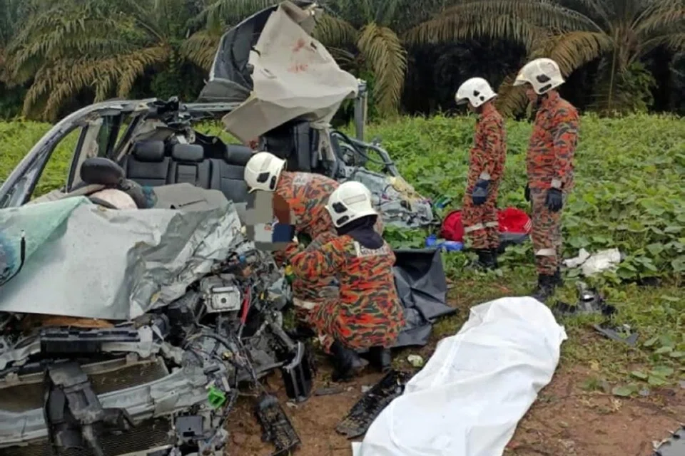 நொறுங்கிப்போன காரிலிருந்து உடல்களை மீட்க முயலும் தீயணைப்பாளர்கள்.