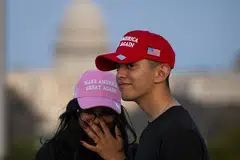 ‘மேக் அமெரிக்கா கிரேட் அகேன்’ என்ற டோனல்ட் டிரம்ப்பின் முழக்கவரியைக் கொண்ட தொப்பிகளை அணியும் மக்கள்.