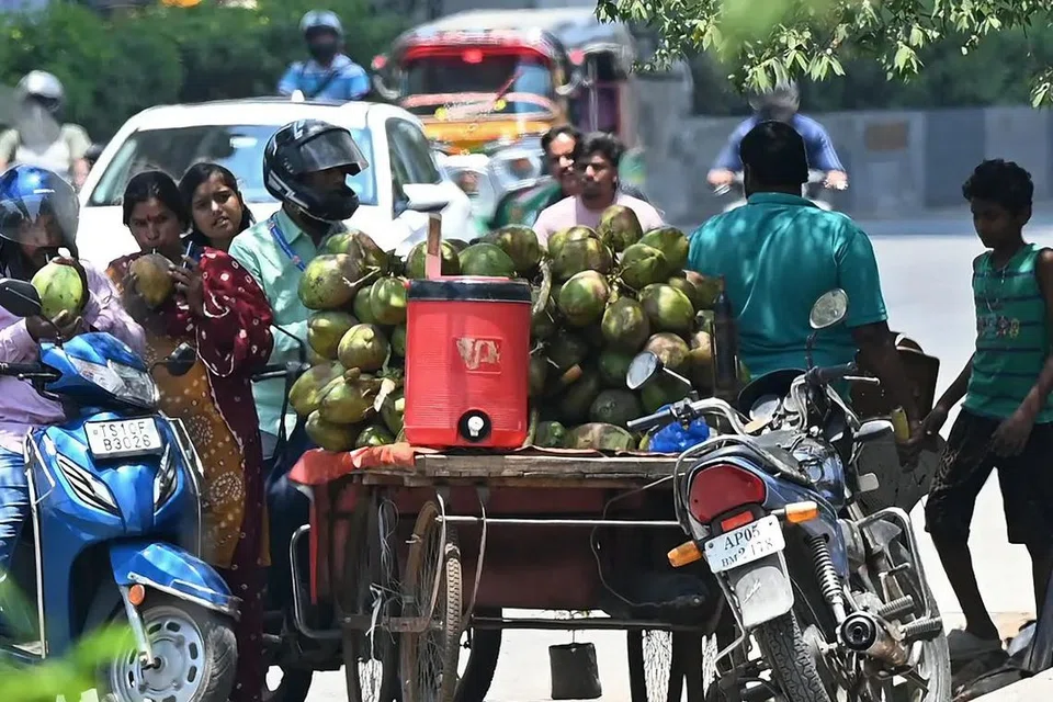 வெயிலின் கொடுமையில் இருந்து தங்களைப் பாதுகாத்துக்கொள்ள இளநீர் அருந்தும் பொதுமக்கள்.  