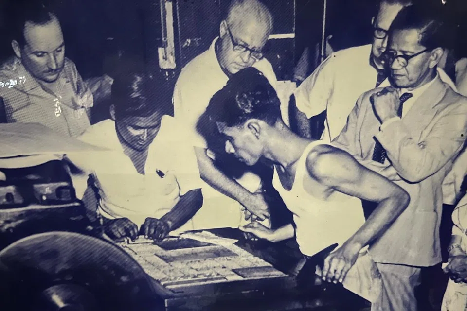 ஆரம்பகால செய்தித்தாள் தயாரிப்பில் பக்கங்களை அச்சு பிரதி எடுக்கும் அச்சுக்கூட ஊழியர்கள்.