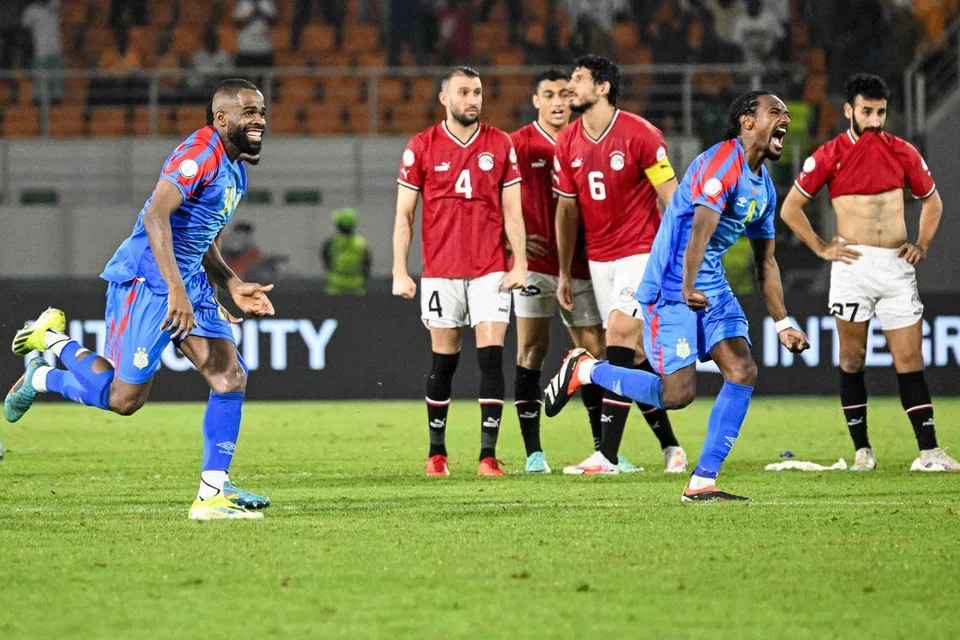 பெனால்டி வாய்ப்புகளில் வென்ற காங்கோ ஆட்டக்காரர்கள் (நீல நிறச் சீருடை) வெற்றியைக் கொண்டாட, தோல்வியால் மனமுடைந்து போயிருக்கும் எகிப்திய ஆட்டக்காரர்கள். 