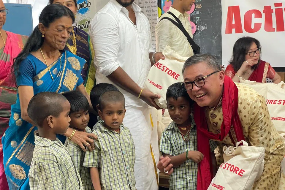 ஜெயபிரகாஷ் படித்த பள்ளி மாணவர்களுக்கு அன்பளிப்புப் பைகளை வழங்கும் திரு டோமினிக்.