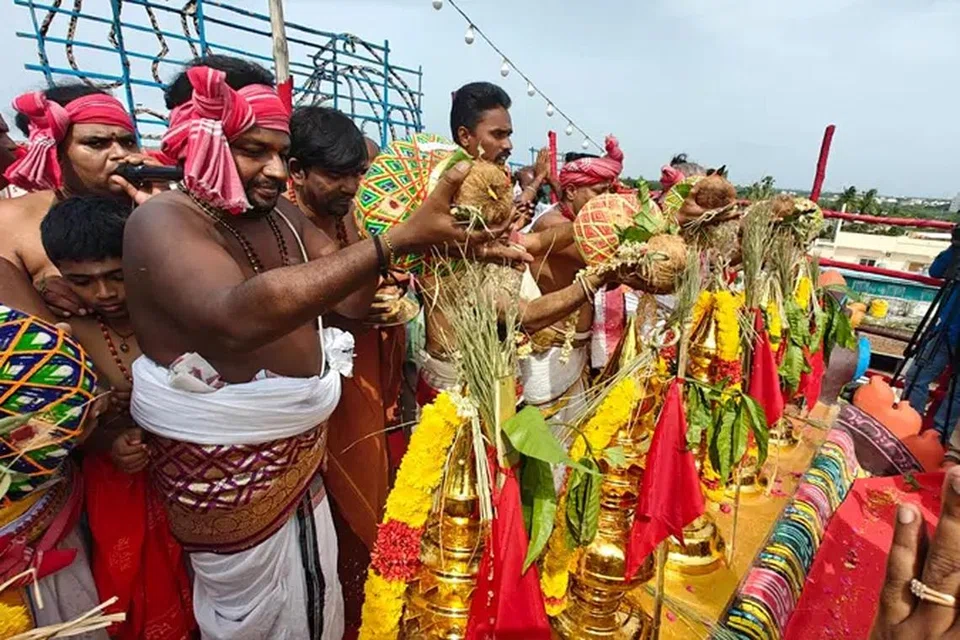 ராஜ கோபுரத்தில் இருக்கும் கும்ப கலசங்களுக்கு அர்சசகர்கள் குடத்தில் இருந்து புனித நீரை ஊற்றுகின்றனர்.