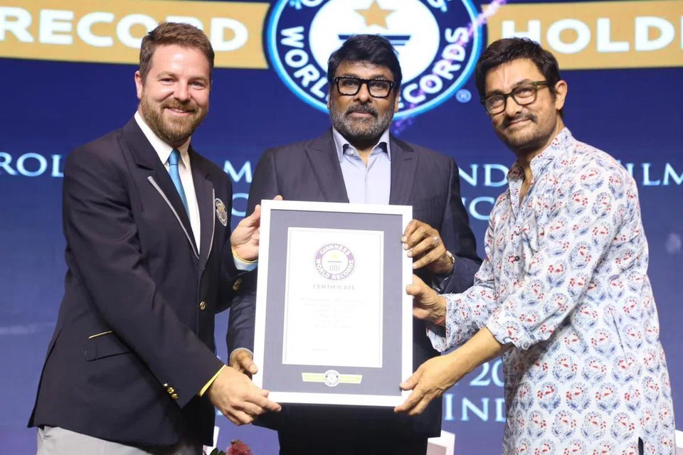 கின்னஸ் சாதனைப் புத்தகத்தில் இடம்பெற்றதற்காக சிரஞ்சீவிக்கு (நடுவில்) பாலிவுட் நடிகர் அமீர் கான் (வலது) விருது வழங்கினார்.