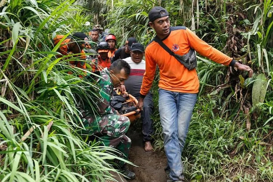மலையிலிருந்து சடலங்களை மீட்புப் பணியாளர்கள் கீழே கொண்டு வருகின்றனர்.