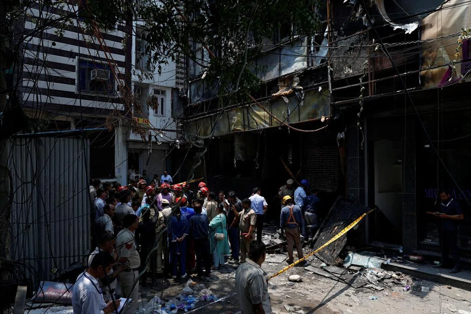 Firefighters and police officers stand at the site after a fire at a hotel in New Delhi, India, June 3, 2026. REUTERS/Adnan Abidi