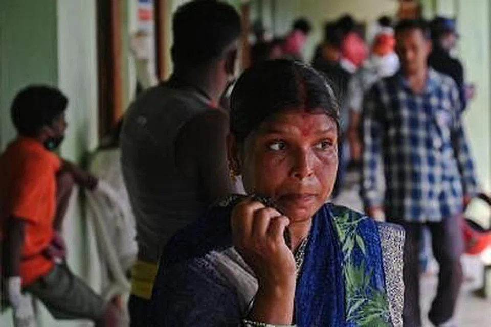 தற்காலிக சவக்கிடங்காக பயன்படுத்தப்படும் உயர்நிலைப் பள்ளியில் தம் உறவினரின் உடலை அடையாளம் காண காத்திருக்கும் மாது. படம்: ஏஎஃப்பி