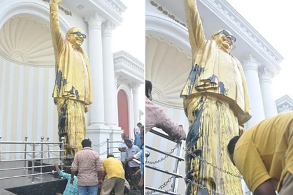 கருணாநிதி சிலை மீது வீசப்பட்ட கறுப்புச் சாயத்தைத் துடைத்து, துப்புரவுசெய்யும் பணியில் ஊழியர்கள்.