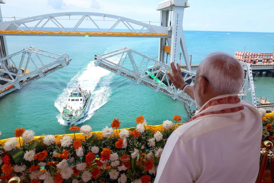 பாம்பன் தூக்கு ரயில் பாலத்தைத் திறந்துவைத்தபின் அவ்வழியாக இயக்கப்பட்ட கடலோரக் காவல்படைக் கப்பலைக் கையசைத்து வரவேற்கும் இந்தியப் பிரதமர் நரேந்திர மோடி.