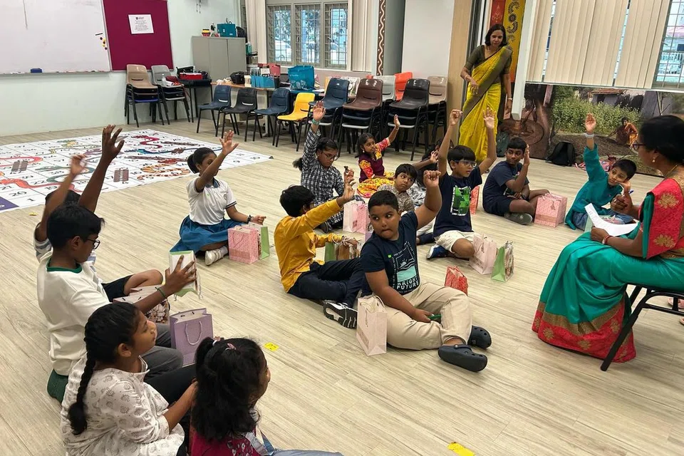 திருமதி நல்லதம்பி கேட்கும் கேள்விகளுக்கு விடையளிக்க ஆர்வத்துடன் கைகளைத் தூக்கிக் காண்பிக்கிறார்கள் சிறுவர்கள்.