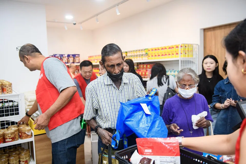 சமூகக் கடையிலிருந்து பொருள்களைத் தேர்ந்தெடுக்கும் திருவாட்டி விமலாவும் அவரது சகோதரரும்.
