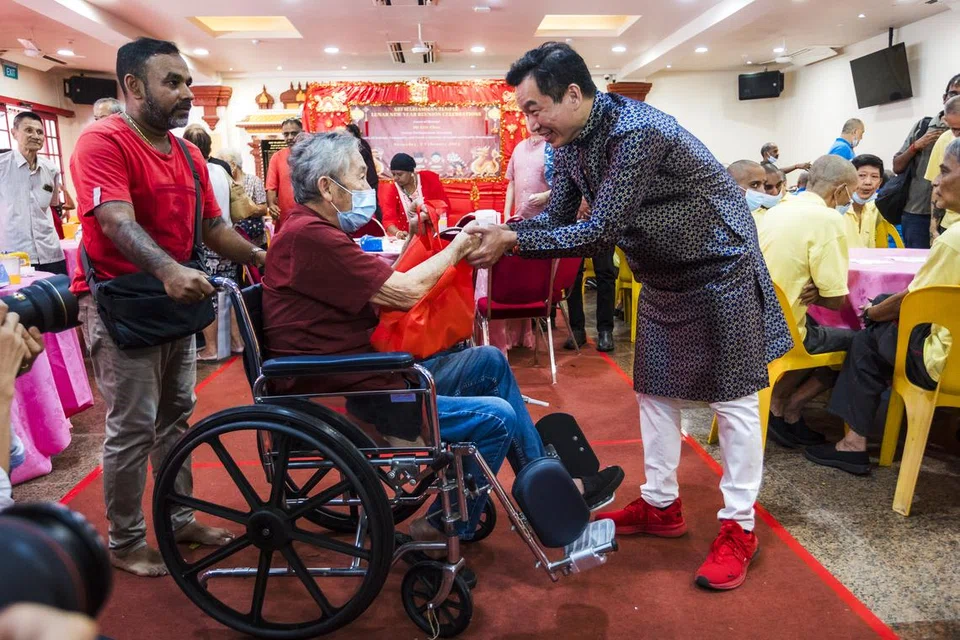 சிறப்பு விருந்தினர் திரு எரிக் சுவா (வலது) ஸ்ரீ மாரியம்மன் கோயிலின் சீனப் புத்தாண்டு மதிய விருந்துக்கு வந்திருந்த முதியவர் ஒருவருக்கு சீனப் புத்தாண்டு அன்பளிப்பு வழங்கினார். 