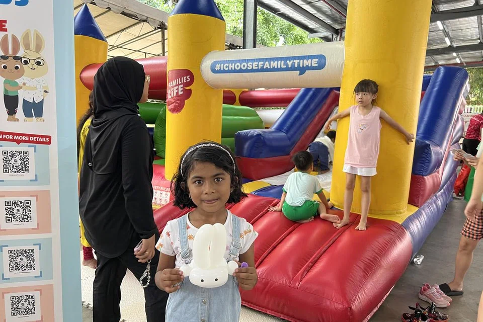 தனக்குக் கிடைத்த முயல் பலூனைக் கையில் வைத்திருக்கிறார் ஜியா ஆன்விர்.