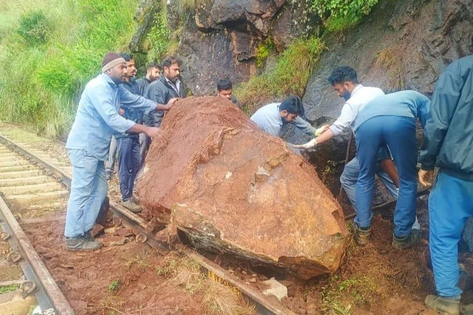 ஊட்டி ரயில் பாதையில் உருண்டு விழுந்த பாறையை அகற்றும் பணியில் ஈடுபட்டுள்ளனர் ரயில்வே ஊழியர்கள்.