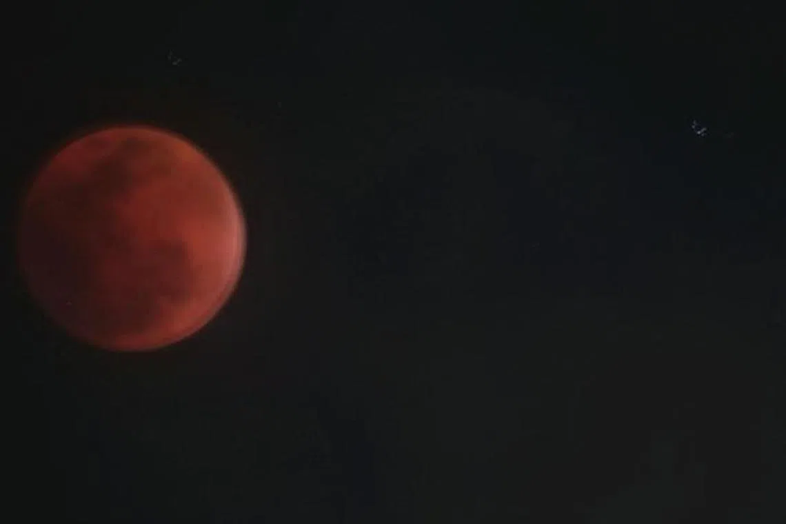 மேகங்களுக்கு இடையே சிவந்த நிலவு கண்ணாமூச்சி 