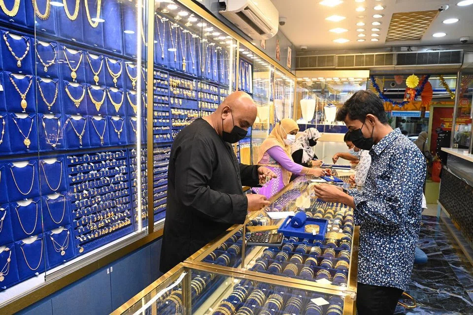 லிட்டில் இந்தியாவில் இருக்கும் நகைக் கடை ஒன்றில் வாடிக்கையாளருக்கு நகைகளைக் காண்பிக்கும் விற்பனையாளர்.