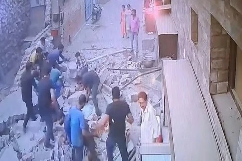 இடிபாடுகளில் சிக்கியிருப்பவர்களை மீட்கும் பணியில் அருகில் இருந்த குடியிருப்பாளர்கள்.