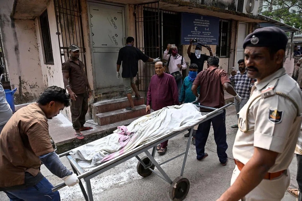 தீ விபத்தில் சிக்கி உயிரிழந்த ஒருவரின் உடலைக் கொண்டுசெல்லும் மருத்துவப் பணியாளர்கள்.