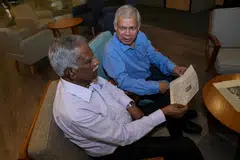 1950களில் சிறுவர்களாக மாணவர் மணிமன்ற உறுப்பினர்களாக இருந்த 77 வயது செ. ப. பன்னீர்செல்வம் , 79 வயது துரைமாணிக்கம் ஆகியோர், திரு பன்னீர்செல்வத்தின் இளம்பருவ படத்தைக்கொண்டுள்ள செய்தித்தாளைப் பார்க்கின்றனர்.