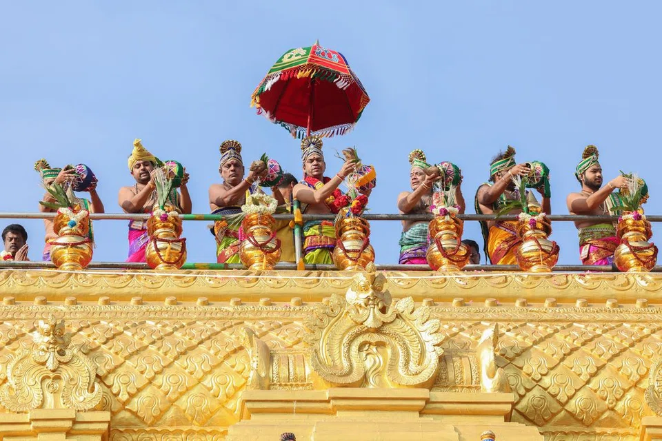 ஏழு கலசம் கொண்ட கோபுரத்தில் புனித நீர் ஊற்றப்படும் காட்சி.