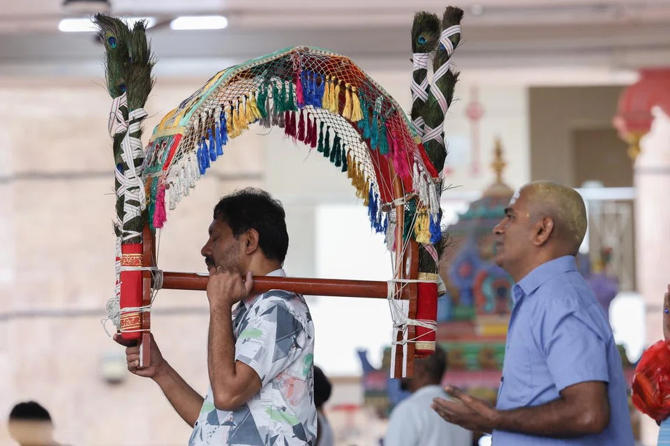 காவடியை அமைத்த பிறகு, அருள்மிகு தெண்டாயுதபாணி கோவிலில் வழிபடும் பக்தர்.